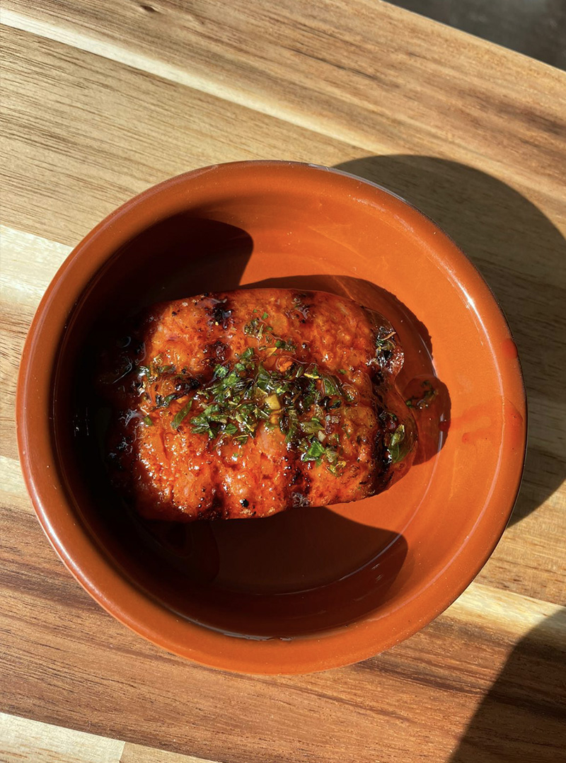 Grilled chorizo sausage with a side of Chimichurri sauce